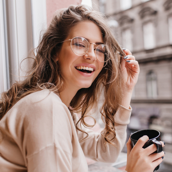 Young Woman with Coffee in Front of Window