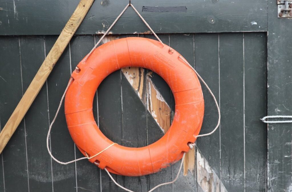 orange lifebuoy hanging on a fence