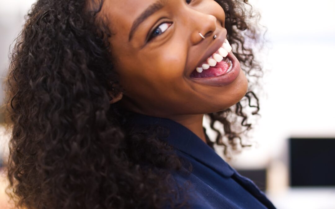 black woman with beautiful smile turning to look at the camera