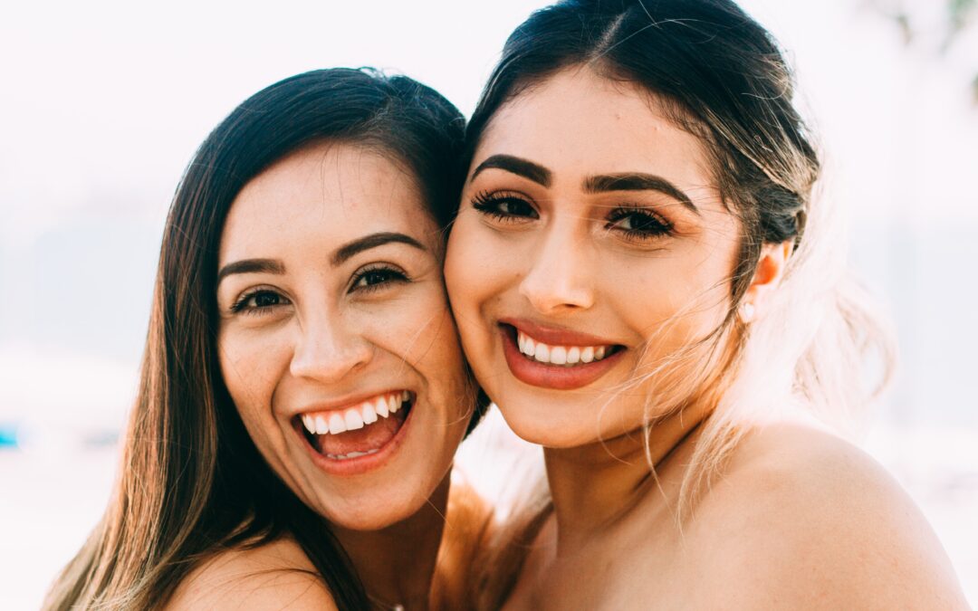 two girls with beautiful teeth smiling at the camera