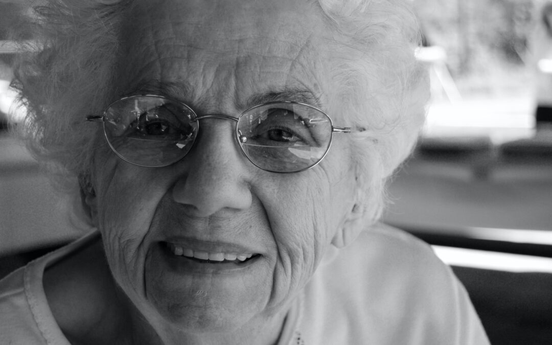 black and white portrait of elderly woman smiling at the camera