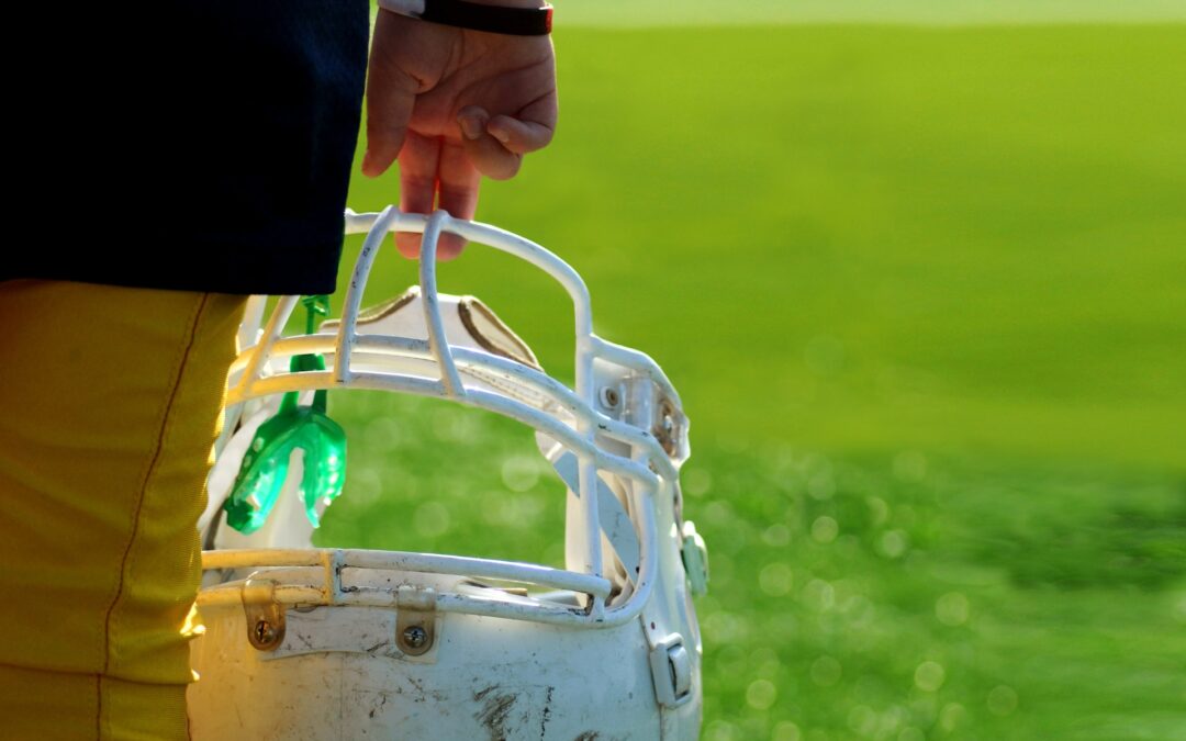 young football player holding his helmet and mouthguard