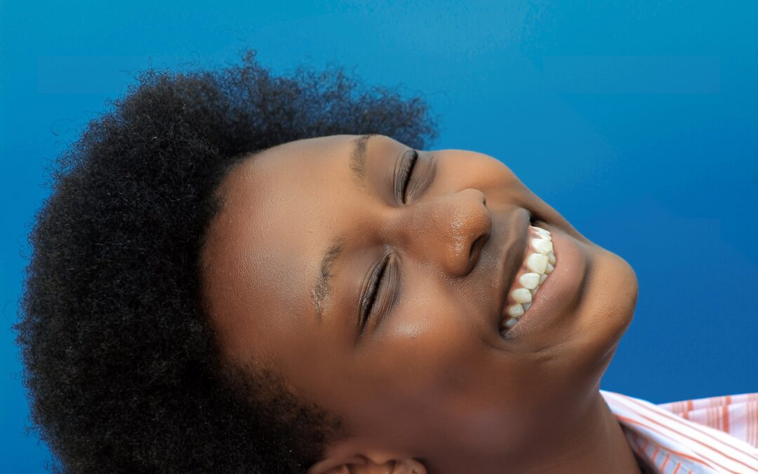 black woman smiling after teeth whitening on blue background