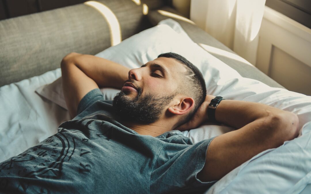 man sleeping with a sleep appliance with hands behind his head with