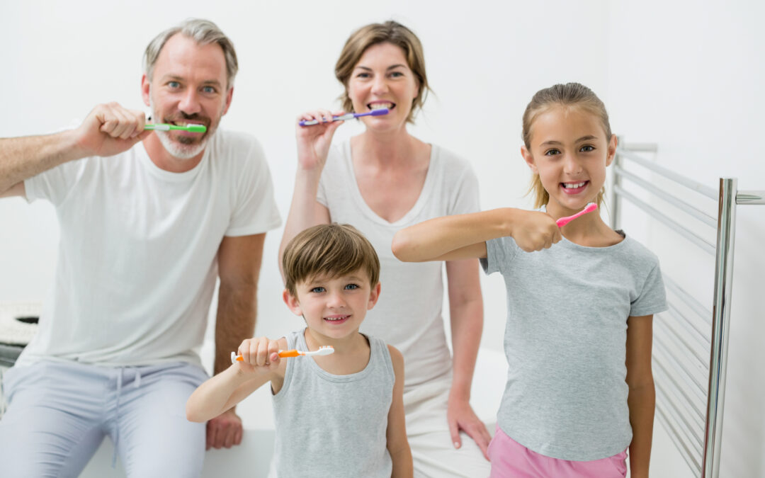 Portrait of smiling family brushing their teeth with toothbrush at home