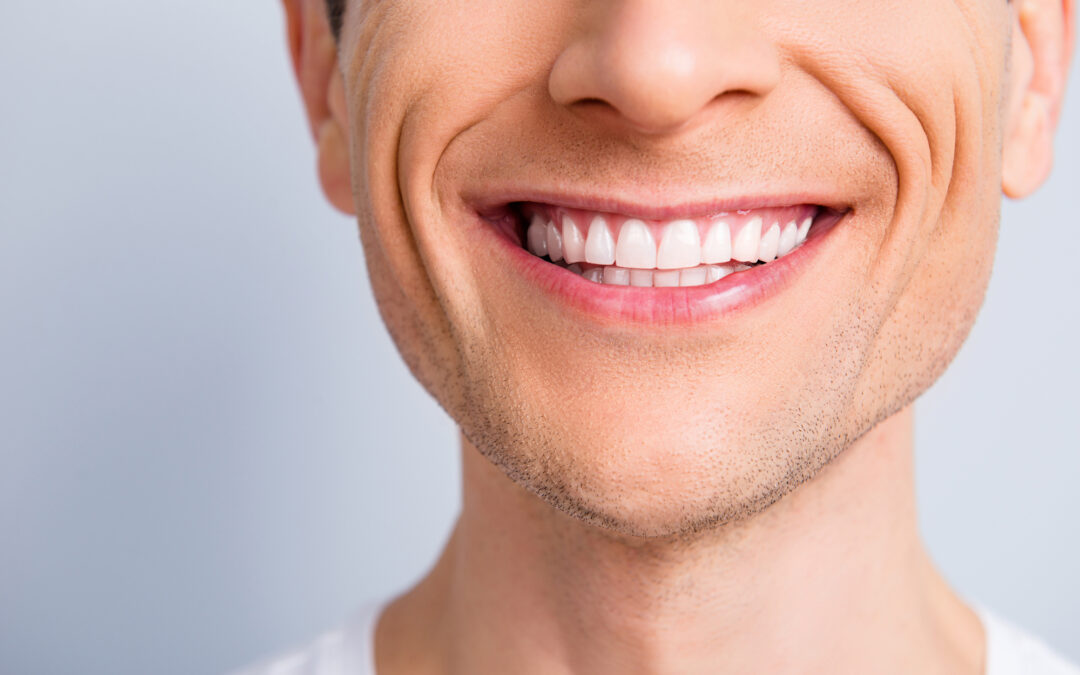 Close up cropped half face portrait of attractive, trendy, stylish, experienced, brunet, toothy man with wide beaming smile and healthy teeth, isolated on grey background