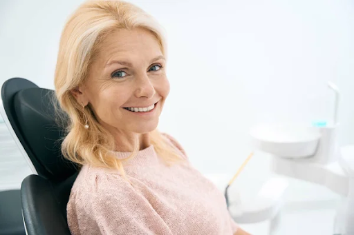 A woman smiling and sitting in a dentist’s chair