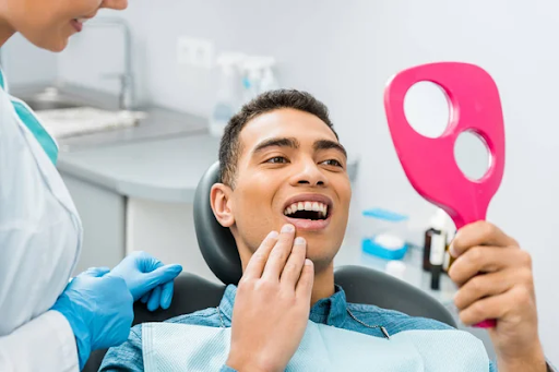 A man at his routine dentist appointment in Naperville, Illinois, using a hand-held mirror to see his teeth.