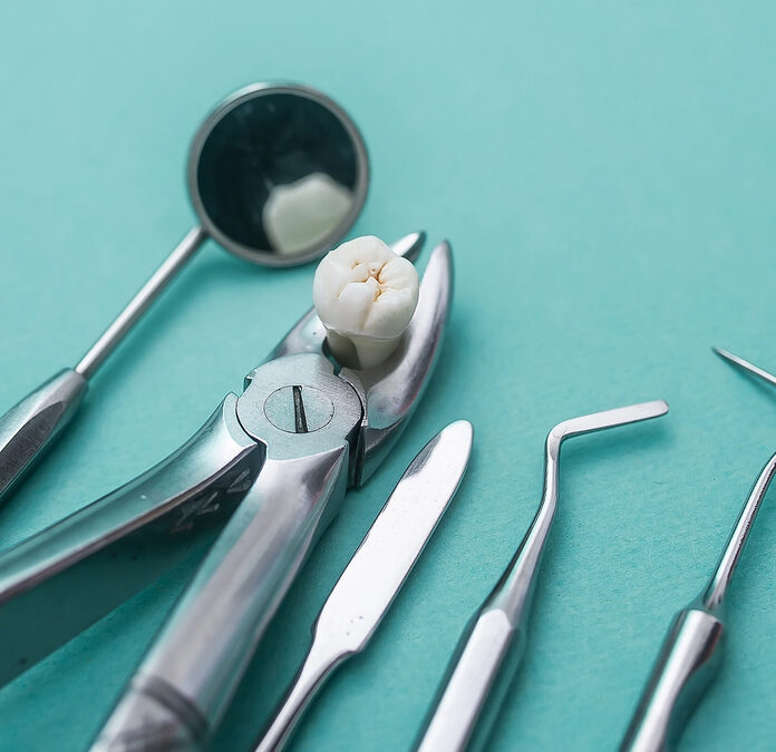 tooth on dental table with tools after tooth extraction