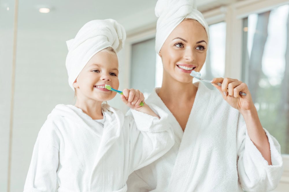 mom and daughter brushing teeth