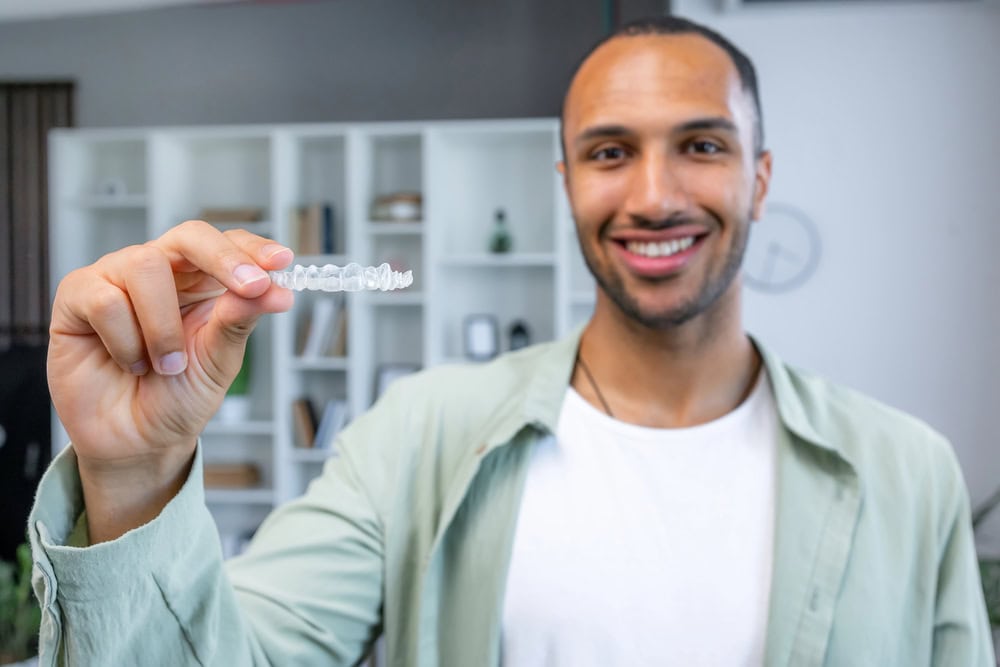 man holding Invisalign clear aligners