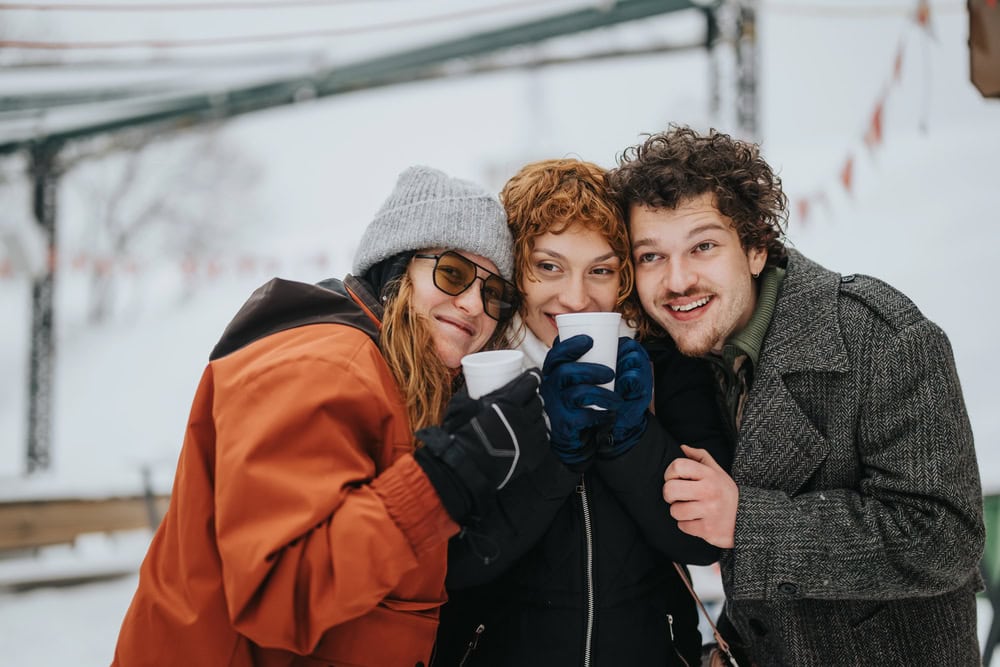 three friends with hot chocolate in winter